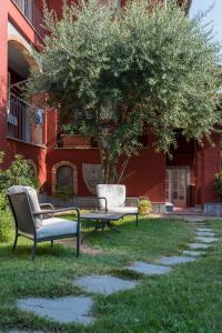 拉莫拉Villa Goccia di Vino的两把椅子和一张桌子,一棵树在一座建筑前面