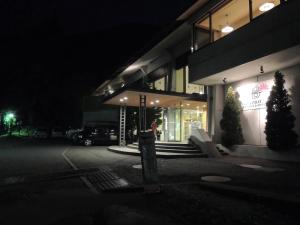 富士河口湖河口湖布瑞百湖度假酒店的夜间站在建筑物外的女人