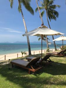 湄南海滩列侬梅森别墅的海滩上设有两把椅子和一把遮阳伞,大海上设有