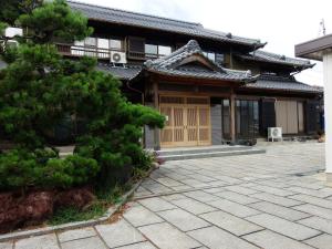 桑名市Minpaku Nagashima room1 / Vacation STAY 1028的前面有松树的亚洲房屋