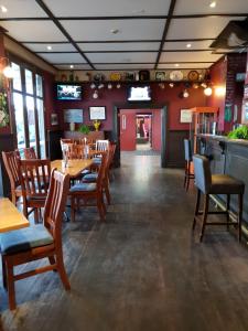 玛塔玛塔赛马骑师旅馆的一间带木桌椅的餐厅和一间酒吧