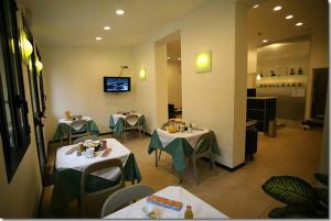 米兰帕拉迪索酒店的餐厅设有两张带绿桌布的桌子