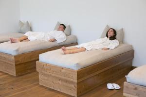 奥伊根多夫萨尔茨堡豪尔兹纳维尔特酒店的两人躺在房间里的床上
