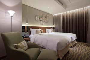 台北洛碁大饭店建北馆的酒店客房,配有两张床和椅子