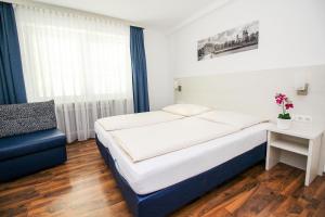慕尼黑奥林匹亚酒店的配有一张床和一把椅子的酒店客房