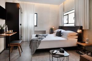 特拉维夫维拉酒店的卧室配有一张白色的大床和一张桌子