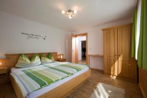 弗林肯贝格伯格霍夫盖斯勒公寓式酒店的一间卧室配有带绿色和白色枕头的床