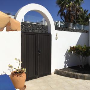 普拉亚布兰卡Sol y Luna Room & Suite Lanzarote Holidays的白色建筑中一扇石墙门