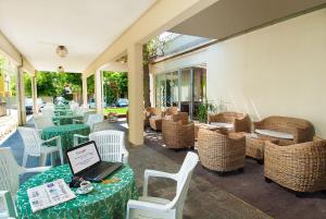 西尼加利亚利昆尔齐酒店的天井配有桌椅和笔记本电脑(桌子上)