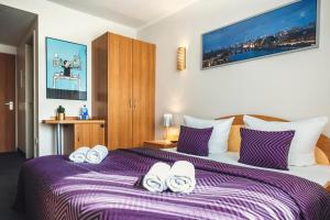 柏林柏林安比特酒店的一间卧室配有一张大床和紫色毯子