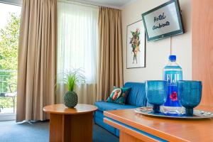 柏林柏林安比特酒店的客厅配有蓝色的沙发和一瓶水