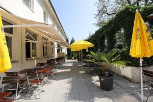 慕尼黑科博尔酒店的一个带桌椅和黄色遮阳伞的庭院