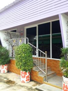 亚兰Muean Fhan Resort Aranyaprathet的窗户前有楼梯的房子