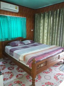 亚兰Muean Fhan Resort Aranyaprathet的一间卧室配有一张带蓝色窗帘的大床