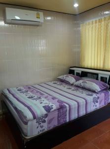 亚兰Muean Fhan Resort Aranyaprathet的一张带紫色和白色床单及枕头的床
