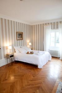 维列莫尔贡贝尔维尤城堡住宿加早餐旅馆的卧室设有一张白色大床和木地板