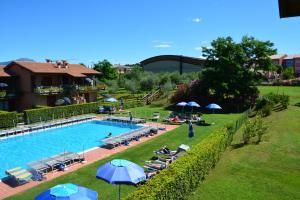 拉齐塞科尔特卡萨拉公寓酒店的游泳池配有椅子和遮阳伞,周围的人可以围着游泳池