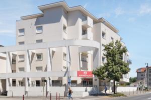 托农莱班Appart'City Classic Thonon Les Bains的一条城市街道上的白色大建筑