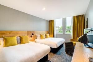 爱丁堡阿佩克斯跳蚤市场酒店的酒店客房配有两张床和一张书桌
