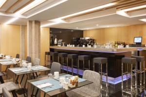 巴塞罗那加泰罗尼亚伊克斯普拉扎酒店的餐厅设有酒吧和桌椅