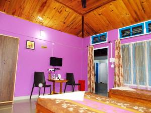 古瓦哈提Eagle Nest Home Stay的一间拥有紫色墙壁和桌椅的房间