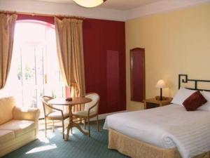 沃特福德林地休闲中心酒店的酒店客房,配有一张床、一张桌子和椅子
