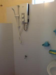 美奈卡沙酒店的带淋浴的浴室,墙上配有电话