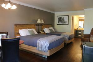 加德纳维尔史学家客栈 的酒店客房带两张床和一张桌子以及椅子。