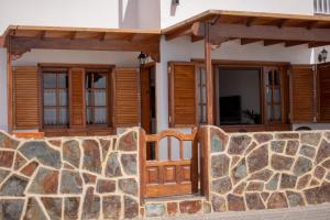 蓬塔穆赫雷斯Ayfa Apartment的一座带木门和石墙的房子