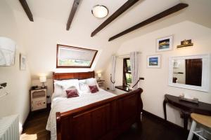 皮特洛赫里老客栈酒店的一间卧室配有一张床、一张书桌和一个窗户。