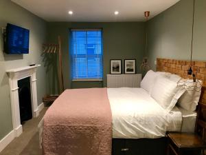 普尔赫利Rooms at Martha Jones的一间卧室设有一张大床和一个壁炉
