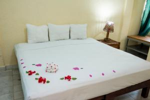 锡瓦塔塔内霍Villa Diamante的卧室配有带鲜花的白色床