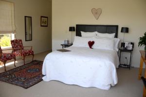 阿卡罗阿拉布里住宿加早餐旅馆的卧室配有白色的床,上面有红色的心