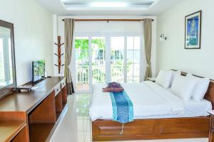 涛岛Ananda Villa - SHA Plus的一间卧室配有一张床、一张书桌和一台电视