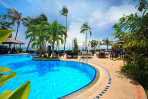 拉迈Rummana Boutique Resort - SHA Plus的棕榈树和大海的游泳池
