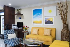 查尔斯顿鹅溪戴斯酒店的客厅设有黄色沙发和玻璃桌