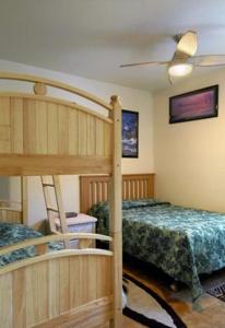 卡帕阿Castle Kaha Lani Resort的一间卧室设有两张双层床和吊扇