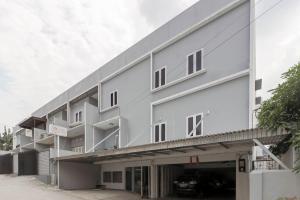 巨港RedDoorz near Siloam Hospital Palembang的一座大型白色建筑,设有停车库