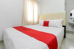 巨港RedDoorz near Siloam Hospital Palembang的一间卧室配有一张带红色毯子的大床