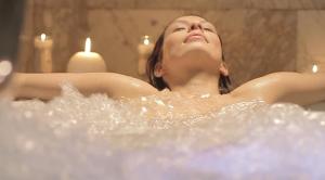 莱萨卡Hotel SPA Atxaspi的把眼睛闭在浴缸里的女人