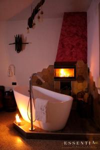 LarinoAgriturismo Essentia dimora rurale的带浴缸的浴室和壁炉。