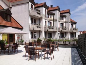 菲尔恩海姆Hotel Post Viernheim UG的建筑前设有带桌椅的户外庭院。