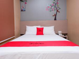 三宝垄RedDoorz near Java Supermall Semarang的卧室配有白色床铺上的红色枕头
