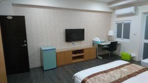 Minxiong三兴会馆民宿的酒店客房设有一张床和墙上的电视