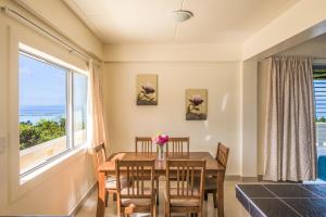 蒂蒂卡韦卡Mai'i Villa Apartment - 1的一间带桌椅和大窗户的用餐室