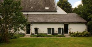 托尔恩Het Kapelhuis的一间白色的房子,有棕色的屋顶和院子