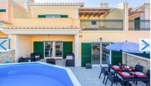 阿尔戈什Marvelous Relaxing Villa with private pool的一个带游泳池、桌子和遮阳伞的庭院