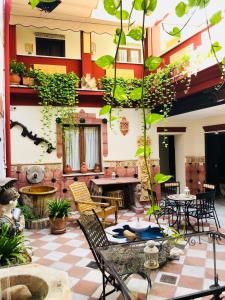 科尔多瓦Apartamentos Medina Qurtuba的庭院设有桌椅和植物