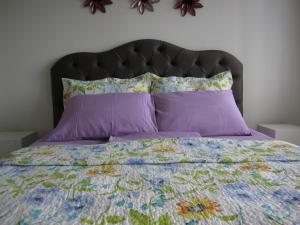 大雅台A Million Dollar View的一张带紫色棉被和紫色枕头的床