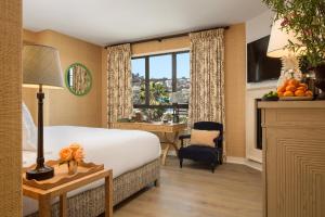 洛杉矶Hotel 850 SVB, West Hollywood, a Member of Design Hotels的配有一张床、一张书桌和一扇窗户的酒店客房